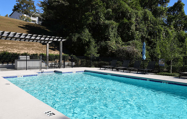 a swimming pool with black chairs and a resort style pool