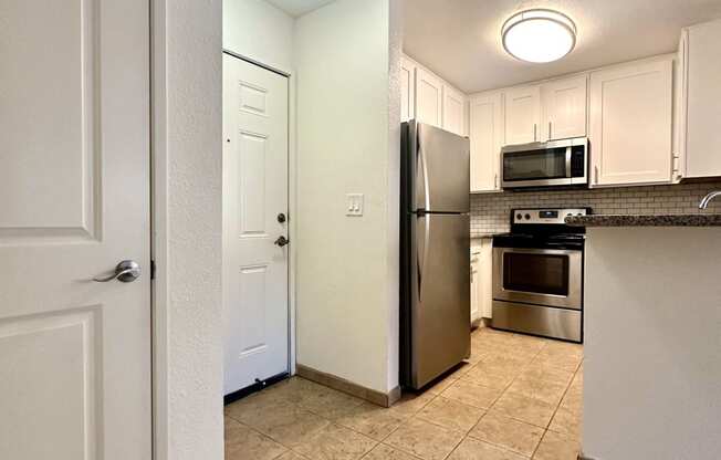 a kitchen with stainless steel appliances and white cabinets