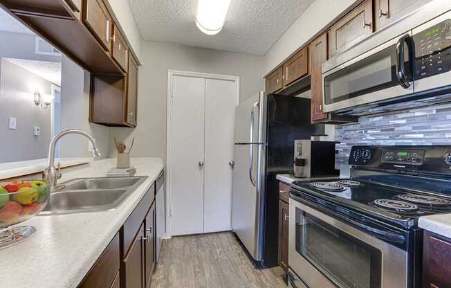 A kitchen with a white fridge and black stove.