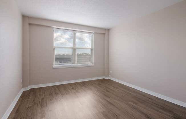 Bedroom with hardwood floors and a window