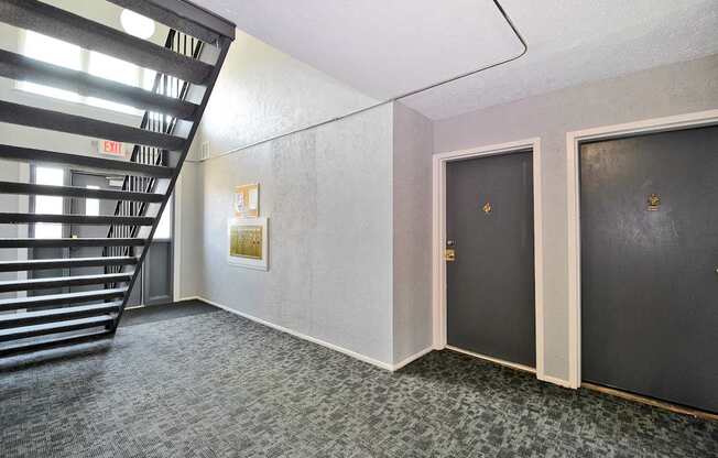 Hallway entrance to apartment with staircase, new carpeting, at Warren Woods Apartments in Warren, MI