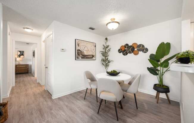 our apartments offer a dining room with white chairs and a table