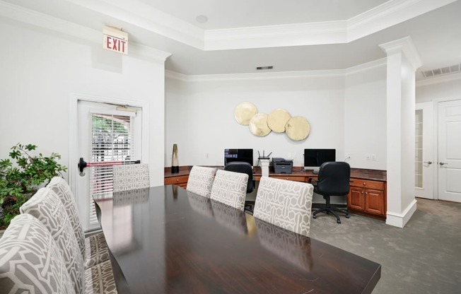 a conference room with white walls and a wooden table and chairs