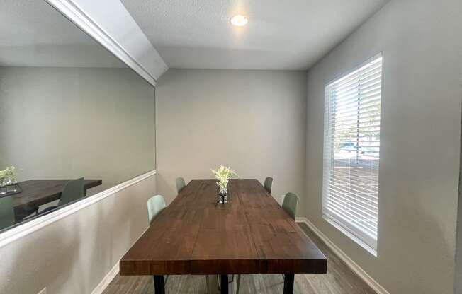 a dining room with a long wooden table and a large window  at 2151 Kirkwood, Houston, 77077