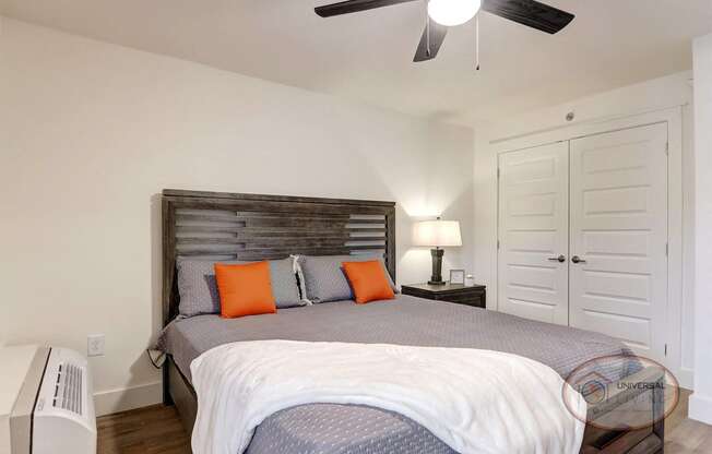 A bedroom with a bed and a ceiling fan.