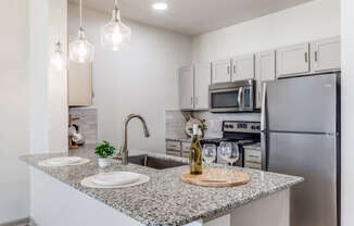 A kitchen with granite countertops and stainless steel appliances.