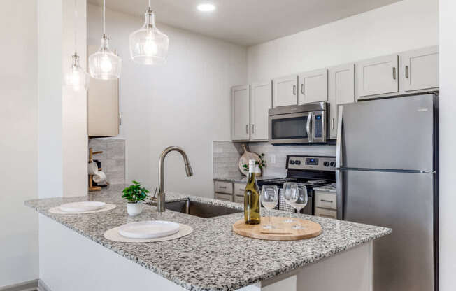 A kitchen with granite countertops and stainless steel appliances.