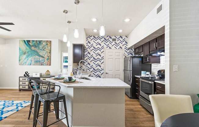 an open kitchen and dining area with bar stools in front of a kitchen island