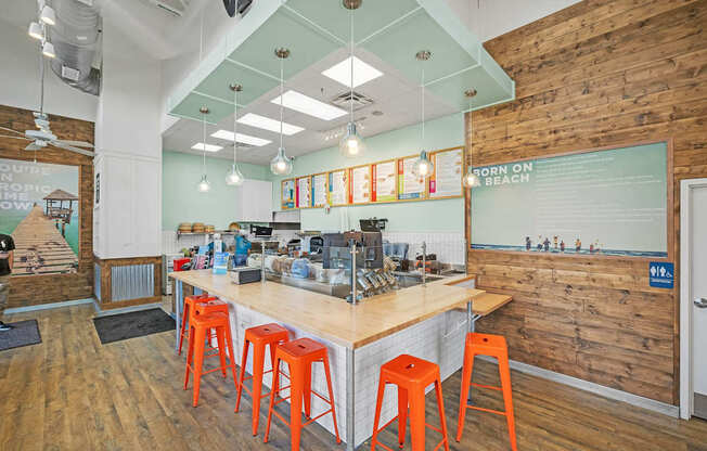 A bar with orange stools and a wooden wall.