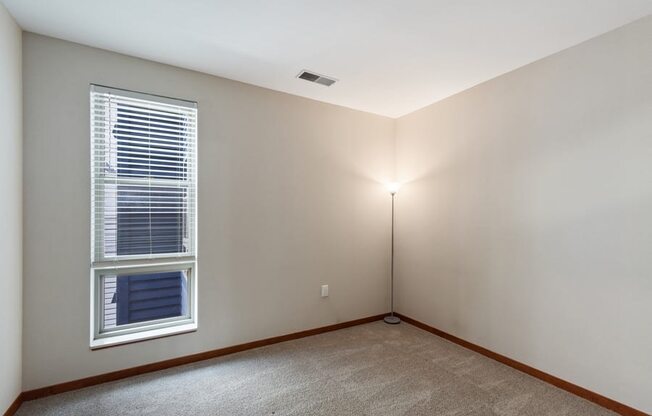 an bedroom with a window and a lamp