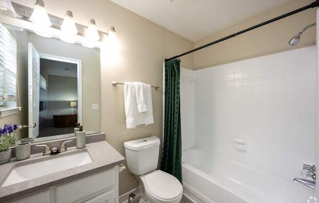 A bathroom with a toilet, sink, and bathtub.