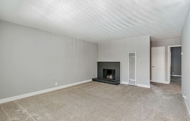 A room with a fireplace and a carpeted floor.