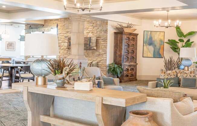 A room with a stone wall and a wooden table with a vase on it.