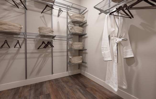 a walk in closet with a robe and hangers