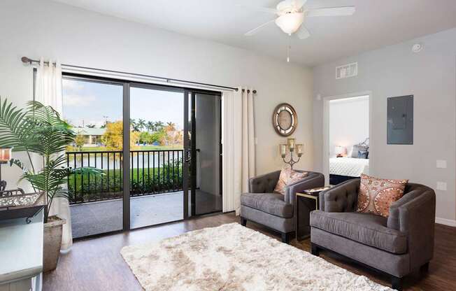 A living room with a grey couch and a white rug.