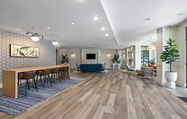 A spacious room with wooden flooring and a long table with chairs.