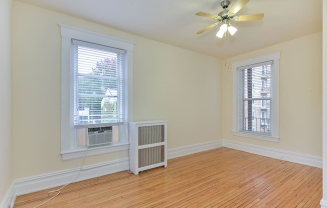 vacant bedroom with hardwood flooring, large windows, and ceiling fan at dupont apartments in washington dc