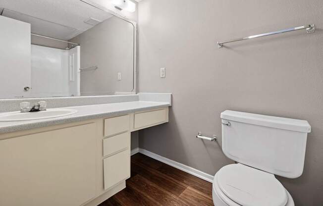 A white toilet sits next to a sink in a small bathroom.