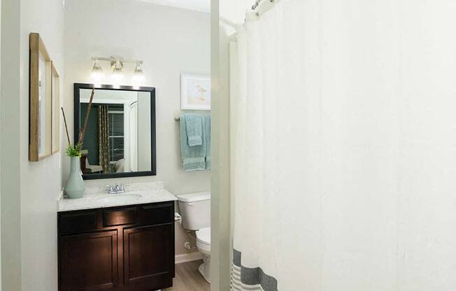 A bathroom with a white toilet and a white shower curtain.