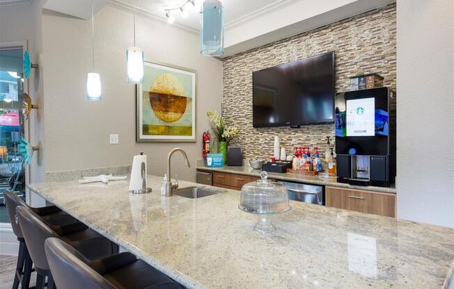 a kitchen with a marble counter top and a tv