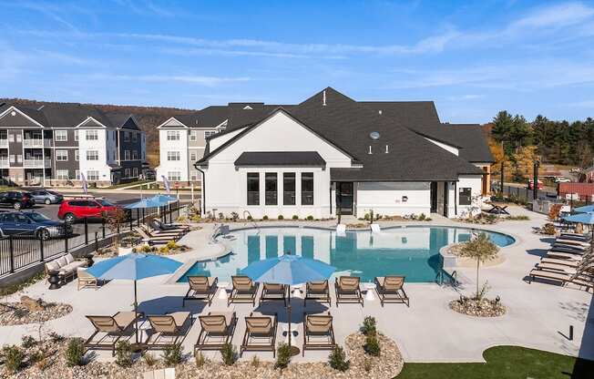 A large white house with a pool in front of it.