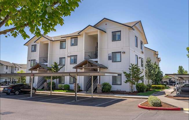 A large white apartment building with a parking lot in front at Riverplace Apartment Homes, Oregon