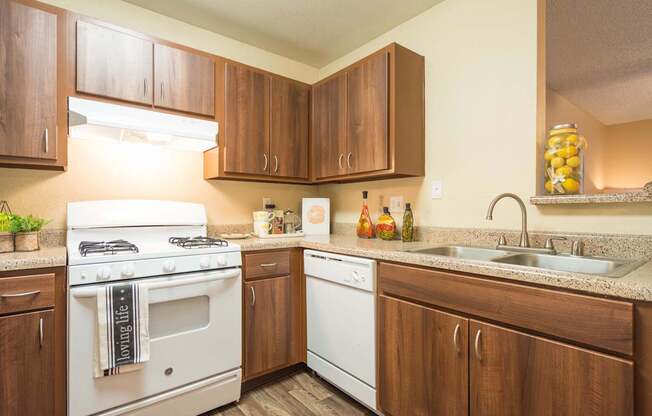 A kitchen with a white stove and wooden cabinets at Sterling Point Apartment Homes, Phoenix, AZ, 85042