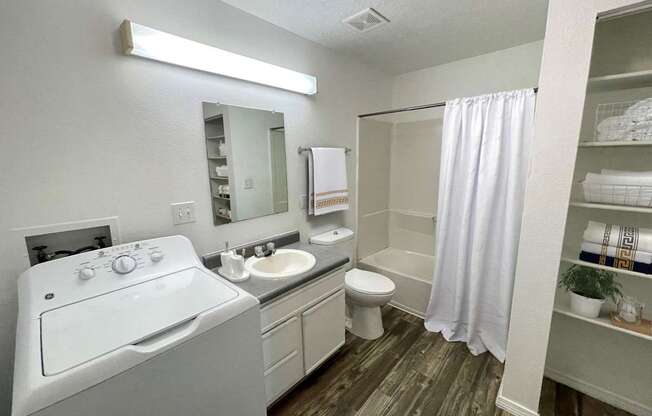 A small bathroom with a toilet, sink, and a washing machine.