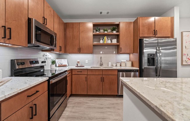 a kitchen with stainless steel appliances and marble counter tops