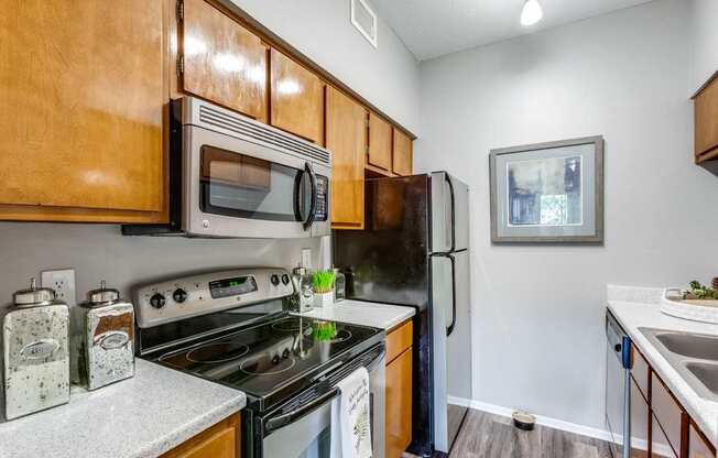 A kitchen with a stove, oven, microwave, and refrigerator.