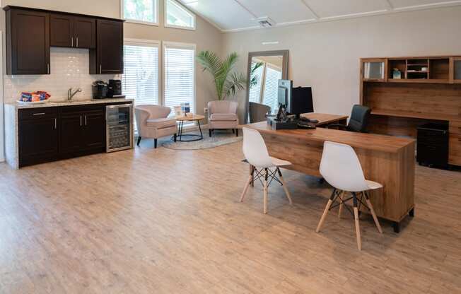 an office with a desk and chairs and a kitchen with a table and chairs