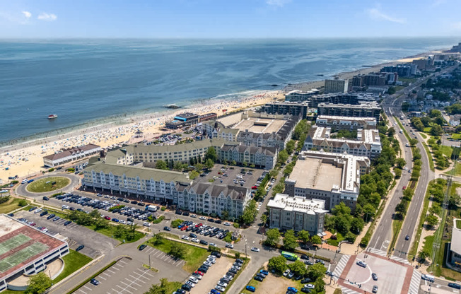 A beachfront cityscape with a parking lot in the foreground.