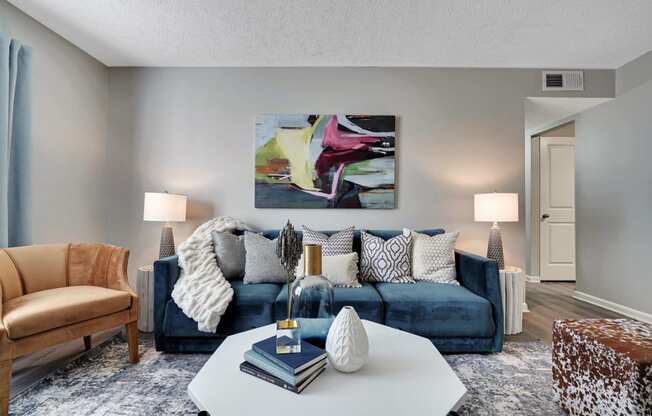 a living room with a blue couch and a white coffee table at Enclave at Breckenridge Apartments, Louisville, KY
