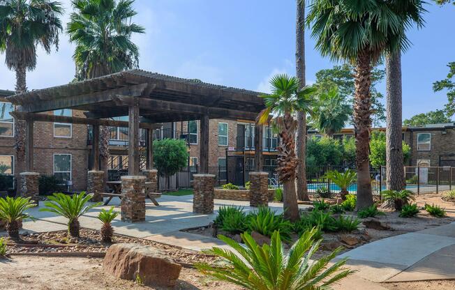 a group of palm trees with a building in the background