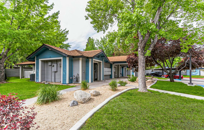 a group of houses in a row with trees and grass in front of them