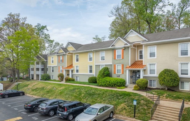 Apartment complex with a parking lot in front.