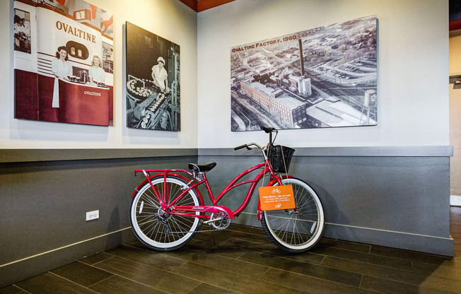 a red bike parked next to a wall in a room