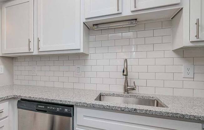 a kitchen with white cabinets and a sink