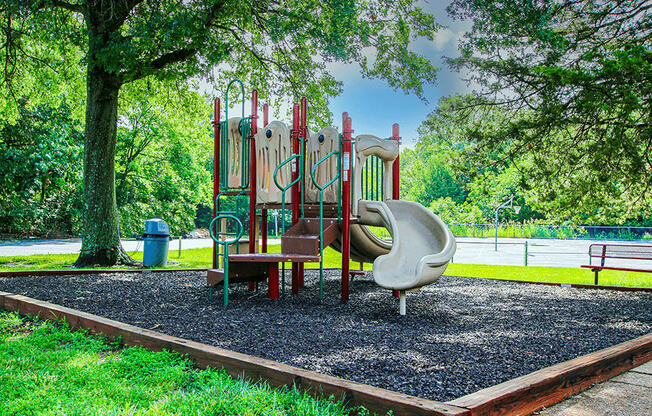 a playground with a swing set and slides in a park