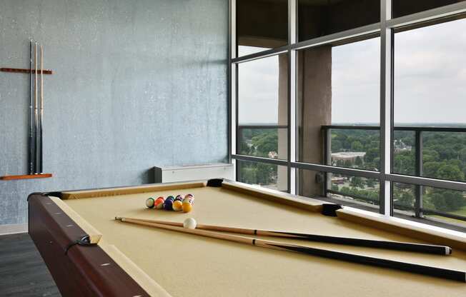 a pool table in a room with a large window