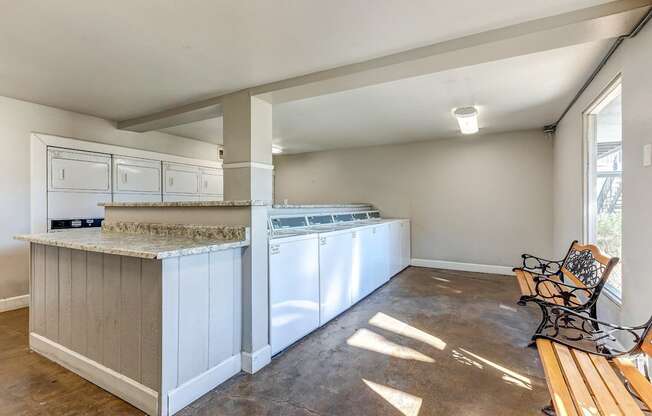 A kitchen with a white counter and a washing machine.