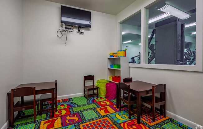 a play room with a table and chairs and a mirror