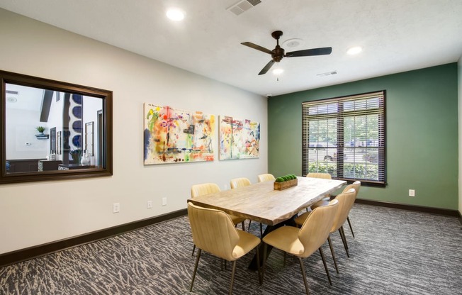 a conference room with a table and chairs and a ceiling fan