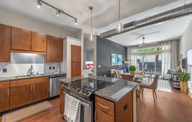 a kitchen with an island and a living room with a table and chairs