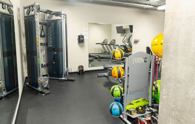 a workout room with weights and mirrors in a gym
