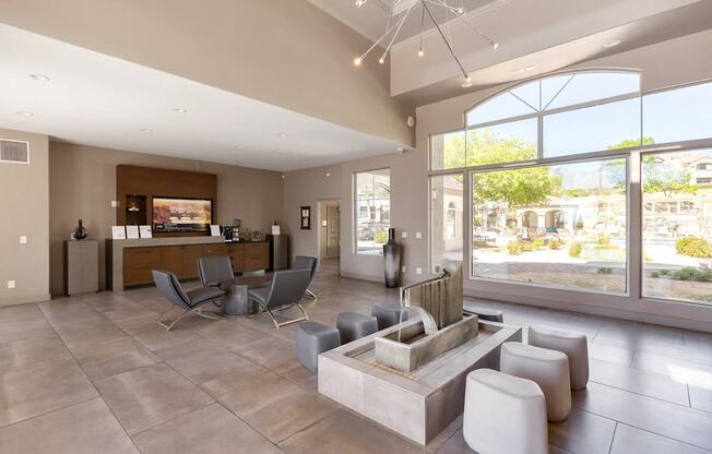 the living room of a clubhouse with a seating area and large windows