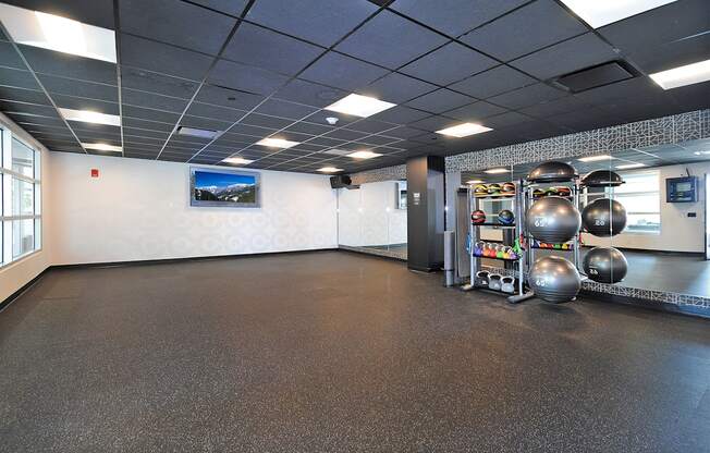 A gym with a variety of equipment including kettlebells and dumbbells.