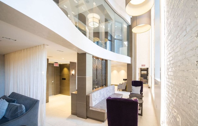 the lobby of a building with purple chairs and a reception desk