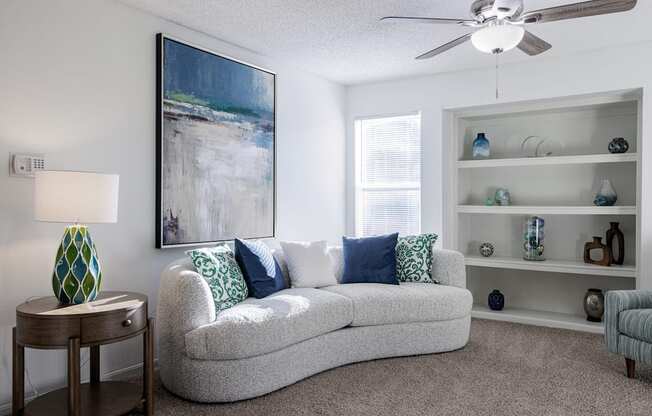 a living room with a couch and a ceiling fan