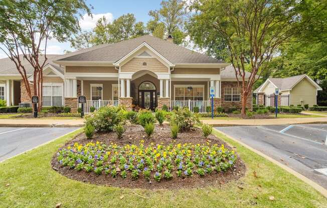 the front of a house with a flower garden in front of it